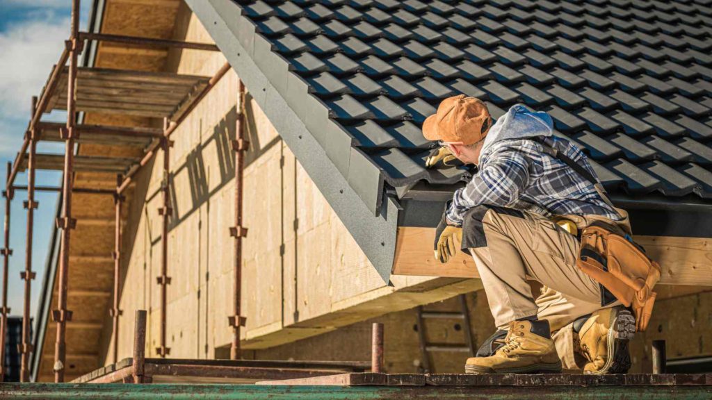 Construction worker inspecting his work on a new roof installation.